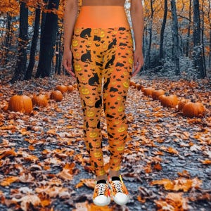 Può includere: Leggings arancioni e nere con una stampa a tema Halloween con zucche, pipistrelli e gatti neri. I leggings sono a vita alta e hanno una vestibilità elastica e confortevole.