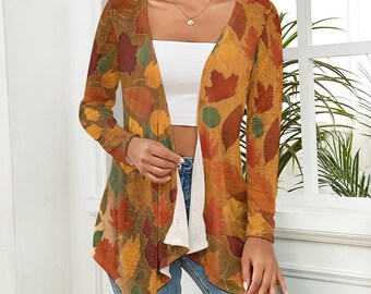 May include: A long-sleeved cardigan with an autumn leaf pattern in shades of brown, orange, red, and green. The open-front cardigan is worn over a white top and blue jeans. The leaf design is repeated across the entire garment.