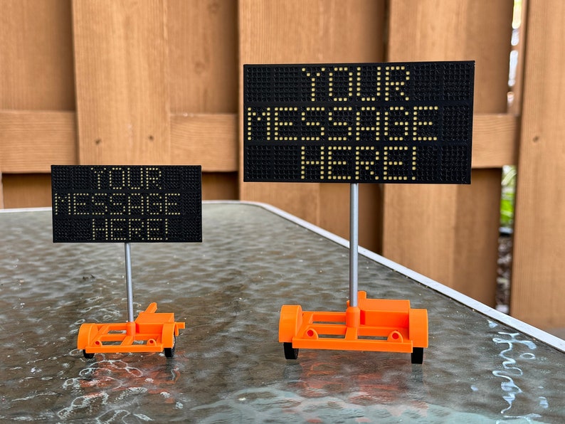 May include: Two black dot matrix displays on orange stands. The larger display reads "YOUR MESSAGE HERE" and the smaller display reads "YOUR MESSAGE HERE".