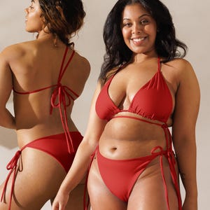 Peut inclure: Deux personnes portant des bikinis rouges. Les bikinis ont des hauts triangulaires et des bas à nouer sur les côtés. Les modèles se tiennent devant un fond neutre. Les maillots de bain sont de couleur rouge vif.