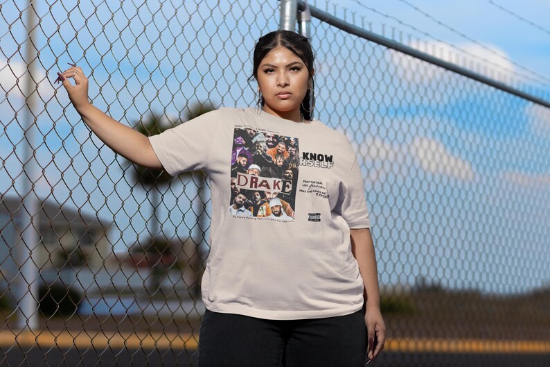 May include: A beige t-shirt with a graphic print of a group of people, including Drake, with the text "KNOW YOURSELF" printed on the front.