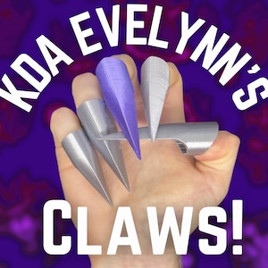 Könnte beinhalten: Eine Hand trägt silberne und violette Fingerkrallen. Der Text "KDA EVELYNN'S CLAWS!" ist im Hintergrund sichtbar.