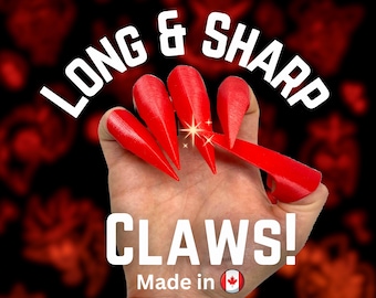 May include: Long and sharp red claws made in Canada. The claws are long and pointed, and they are held in a hand.