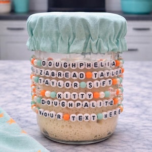 Pode incluir: Uma placa de madeira r&uacute;stica com o texto "Welcome to our home" em letras brancas. A placa apresenta um acabamento desgastado e um design simples e convidativo, ideal para a decora&ccedil;&atilde;o da entrada.