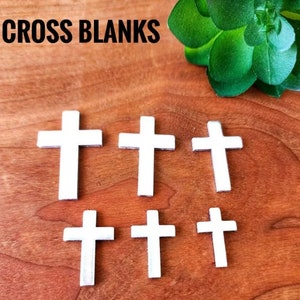Puede incluir: Seis formas de cruz de madera blanca sobre una superficie de madera marrón. El texto "CROSS BLANKS" es visible en la parte superior de la imagen.