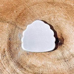 May include: White ceramic cloud-shaped ornament with a smooth, matte finish.