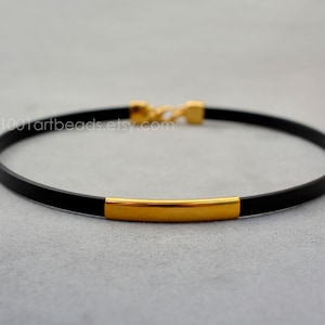 Może przedstawiać: Czarny skórzany naszyjnik choker z złotym paskiem. Naszyjnik to 1001artbeads.etsy.com.