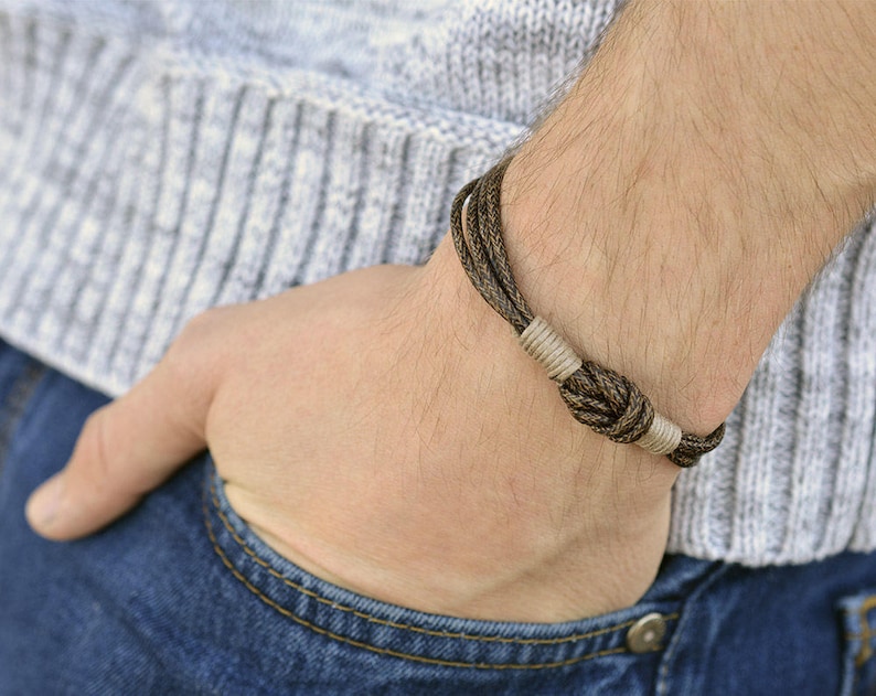 May include: A brown and beige braided bracelet with a knot detail.