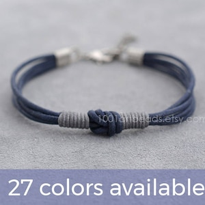 May include: A navy blue braided bracelet with a silver clasp and a knotted design. 27 colors available.