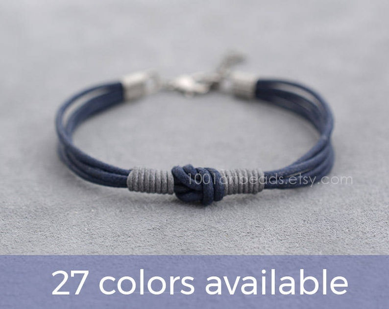 May include: A navy blue braided bracelet with a silver clasp and a knotted design. 27 colors available.
