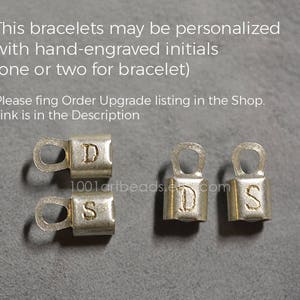 May include: Four silver metal clasps with engraved letters D, S, D, and S. The clasps are used for jewelry making.