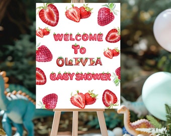 May include: Welcome to Olivia Baby Shower sign with a white background and red strawberry illustrations. The letters are made of strawberries.