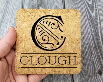 May include: Cork coaster with a black and white initial "C" design and the name "CLOUGH" printed below.