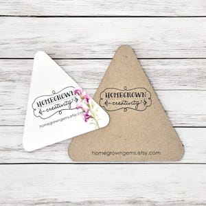 May include: Two triangular business cards with the text "Homegrown Creativity" and the website address "homegrowngegems.etsy.com". One card is white with a floral design and the other is brown.