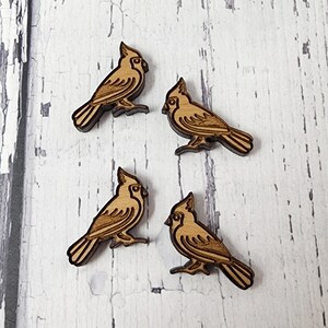 May include: Four wooden cardinal bird ornaments, each with a detailed design and a natural wood finish.