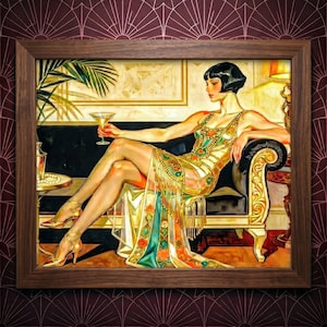 May include: A framed art print depicting a person with a dark bob haircut wearing a gold dress with fringe and colorful circular accents. The person is seated on a black sofa, holding a martini glass, with a palm leaf and a side table visible.