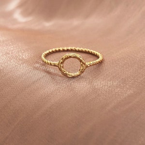 Peut inclure: Une bague en or avec une bande torsadée et un motif circulaire ouvert.