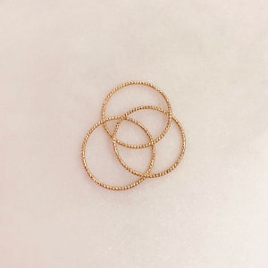 Peut inclure: Trois bagues empilables dorées avec un design texturé et tressé.