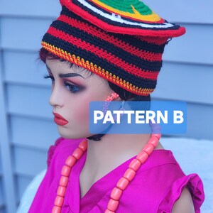 May include: A colorful, patterned hat with a curved brim, featuring red, black, white, yellow, and green stripes. The hat is worn by a mannequin, paired with a pink top and necklace. The text "PATTERN B" is visible.