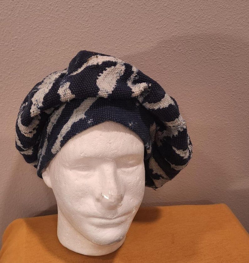 Puede incluir: Boina con estampado azul marino y blanco. El sombrero, hecho de tela texturizada, tiene un dise&ntilde;o a rayas. Se muestra sobre una cabeza de maniqu&iacute; blanca. El fondo es de color neutro. El dise&ntilde;o del sombrero se repite.