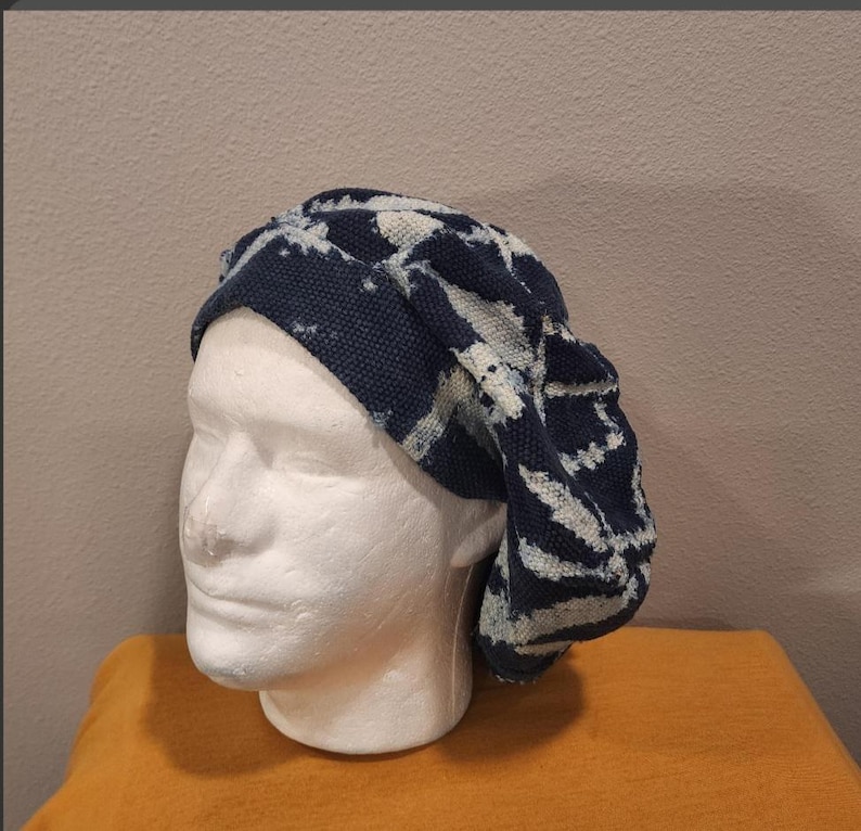 Puede incluir: Un gorro de punto con estampado azul oscuro y blanco. El gorro se exhibe en una cabeza de maniqu&iacute; blanca. El gorro tiene un aspecto suave y texturizado y un ajuste relajado. El gorro es probablemente hecho a mano y adecuado para climas fr&iacute;os.
