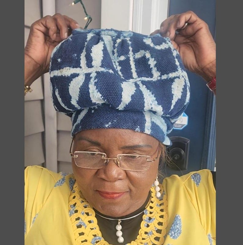 Puede incluir: Un sombrero con estampado azul y blanco. El sombrero est&aacute; hecho de una tela suave y tiene forma redondeada. El sombrero est&aacute; sostenido por las manos de una persona.