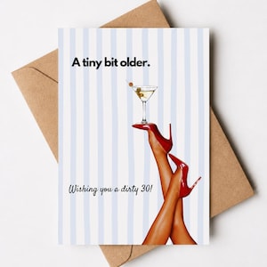 May include: Greeting card with a martini and red high heels. The card has a blue and white striped background and text that reads "A tiny bit older." and "Wishing you a dirty 30!" The card is on a brown envelope.
