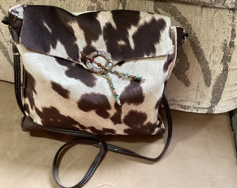 Handcrafted and designed faux cowhide crossbody purse.
