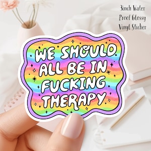 Könnte beinhalten: Ein 7,6 cm großer, wasserfester, glänzender Vinyl-Aufkleber mit einem Regenbogenhintergrund und dem Text "WE SHOULD ALL BE IN FUCKING THERAPY".