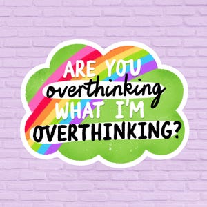 May include: A sticker with a green cloud shape, a rainbow, and the text "ARE YOU overthinking WHAT I'M OVERTHINKING?" in white and black. The sticker is on a light purple brick wall.