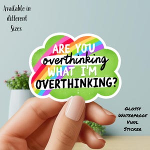 May include: A glossy, waterproof vinyl sticker in a cloud shape with the text "ARE YOU overthinking WHAT I'M OVERTHINKING?" in black and white. The sticker has a rainbow and green background. The text "Available in different Sizes" is also present.