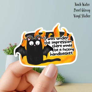 May include: A 7.6 cm water-proof glossy vinyl sticker. It depicts a black cat with horns and bat wings, set against orange flames. The sticker reads: "I was under the impression there would be a fucking handbasket."