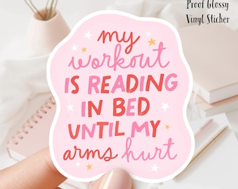 May include: Pink vinyl sticker with the text "my workout is reading in bed until my arms hurt" in red and white lettering with gold stars. 3 inch water proof glossy vinyl sticker.