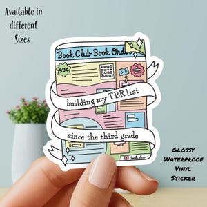 May include: A colorful sticker featuring a book design with the text "Book Club Book Order" and "building my TBR list since the third grade." The sticker is labeled "Glossy Waterproof Vinyl Sticker" and is available in different sizes.
