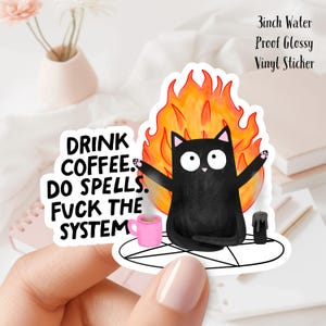Peut inclure: Autocollant de chat noir avec le texte "DRINK COFFEE. DO SPELLS. FUCK THE SYSTEM." Le chat est devant une flamme, avec une tasse rose et une bougie noire. L'autocollant mesure 7,6 cm et est imperméable.