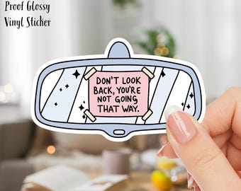 May include: A 3-inch waterproof glossy vinyl sticker featuring a blue car rearview mirror with a pink sticky note that reads "DON'T LOOK BACK, YOU'RE NOT GOING THAT WAY."