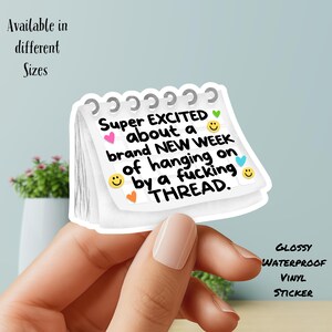May include: A white, glossy vinyl sticker in the shape of a notepad with the text "Super EXCITED about a brand NEW WEEK of hanging on by a fucking THREAD." The sticker has colorful heart and smiley face graphics.