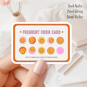以下が含まれることがあります： オレンジ色の縁取りが付いた、7.6 cmの防水光沢ビニールステッカー。「FREQUENT CRIER CARD」と書かれており、スマイリーフェイスが特徴です。「CRY 10 TIMES GET A BOX OF TISSUES FREE!」というテキストも含まれています。