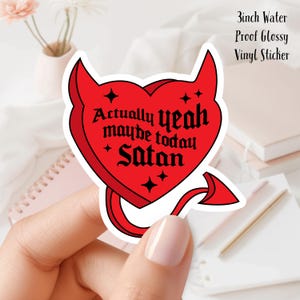 Puede incluir: Una pegatina roja en forma de corazón con cuernos y cola de diablo. La pegatina tiene el texto "Actually yeah maybe today Satan" en fuente gótica negra. La pegatina mide 7.6 cm y es resistente al agua.