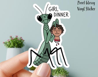 Può includere: Adesivo in vinile lucido e impermeabile raffigurante una mantide religiosa verde che tiene una testa mozzata. Il testo "GIRL DINNER" è sopra la mantide. L'adesivo misura 7,6 cm.