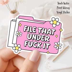 May include: A pink vinyl sticker with the text "FILE THAT UNDER FUCK IT" in bold white letters. The sticker is 3 inches and features daisy and star accents. The sticker is water proof and glossy.
