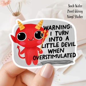 May include: A red devil sticker with yellow horns and a trident. The sticker has the text "WARNING: I TURN INTO A LITTLE DEVIL WHEN OVERSTIMULATED." The sticker is 3 inches and water proof.