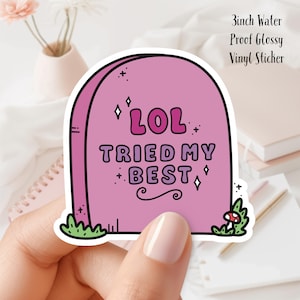 Può includere: Un adesivo in vinile rosa con un design a forma di lapide. L'adesivo dice "LOL TRIED MY BEST" con dettagli glitterati. L'adesivo è largo 7,6 cm.