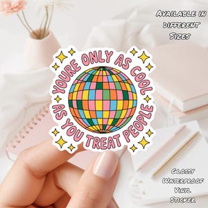 Puede incluir: Adhesivo colorido con un diseño de bola de discoteca y el texto "YOU'RE ONLY AS COOL AS YOU TREAT PEOPLE". El adhesivo es de vinilo brillante e impermeable, disponible en diferentes tamaños.