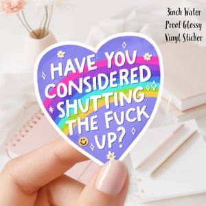 Puede incluir: Una pegatina morada en forma de corazón con el texto "HAVE YOU CONSIDERED SHUTTING THE FUCK UP?" en blanco, rosa y amarillo. La pegatina tiene un diseño de arcoíris y pequeños acentos de flores y diamantes. La pegatina mide 7.6 cm.