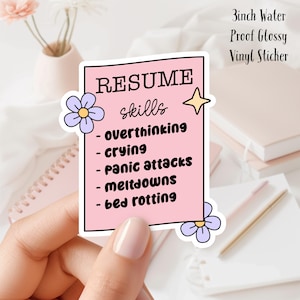 Peut inclure: Un autocollant en vinyle brillant imperméable à l'eau de 7,6 cm avec le texte "RESUME skills" et une liste de compétences : surpenser, pleurer, crises de panique, effondrements, rester au lit. L'autocollant est décoré de deux fleurs violettes.