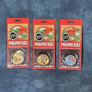 May include: Three sealed red cardboard blister packs of Pogpourri Series II game pieces. Each package features the Pog logo, a cartoon character, and the text 100% Authentic, Pogpourri Series II, and Invest in the Best. Each pack contains a circular game disc.