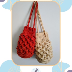 Puede incluir: Dos bolsos de ganchillo hechos a mano cuelgan de una pared gris claro. Uno es rojo, el otro beige. Ambos tienen correas largas y un patrón texturizado en forma de escamas en la parte inferior. Los bolsos son de Knot The Ordinary Crafts.