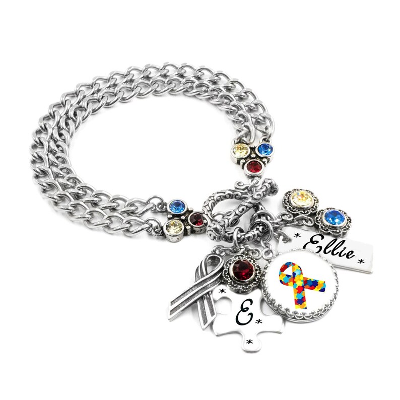 A silver-colored charm bracelet with various charms and charms attached to it.