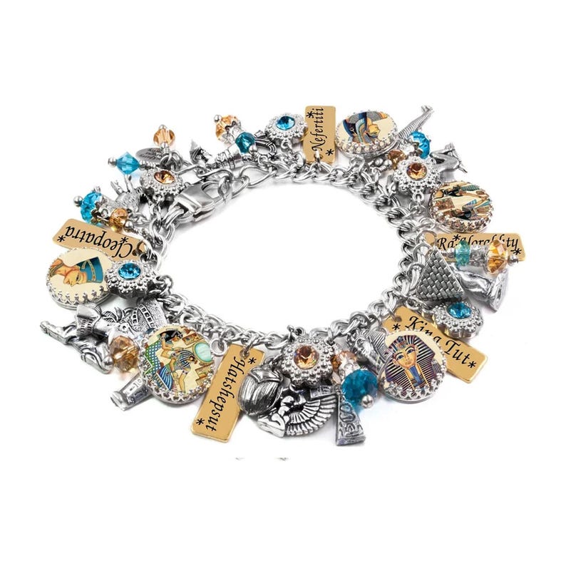 A silver-toned charm bracelet adorned with various Egyptian-themed charms, including a pharaoh, hieroglyphics, and other Egyptian symbols.
